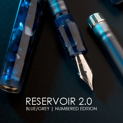 Fountain pen with blue and gray accents on a dark surface, labeled 'Reservoir 2.0'.