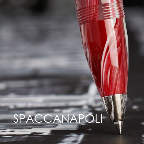 Red pen with silver cap on a blurred background, featuring the brand Delta 'Spaccanapoli'.