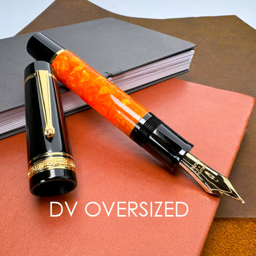 Fountain pen with black and gold accents on a red leather surface with notebooks in the background, labeled 'DV Oversized'.